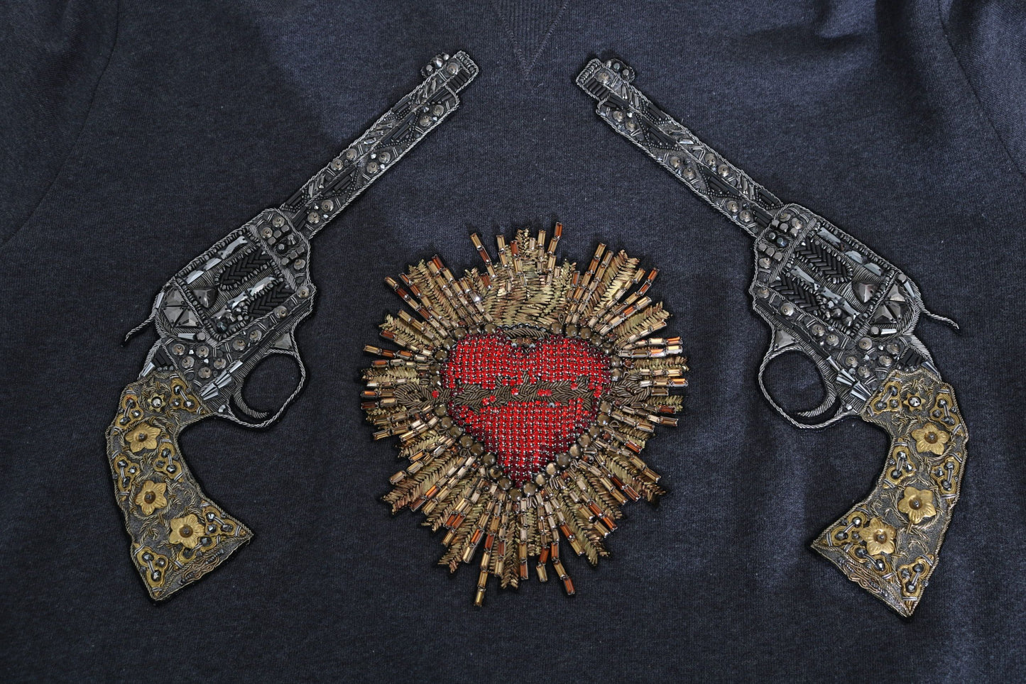 Suéter gris con motivo de pistola y corazón de cristal