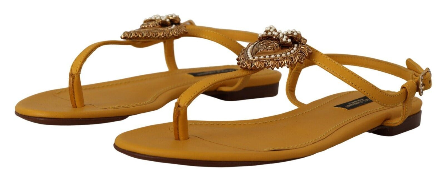 Sandalias planas con tira en T en color mostaza y adorno de corazón