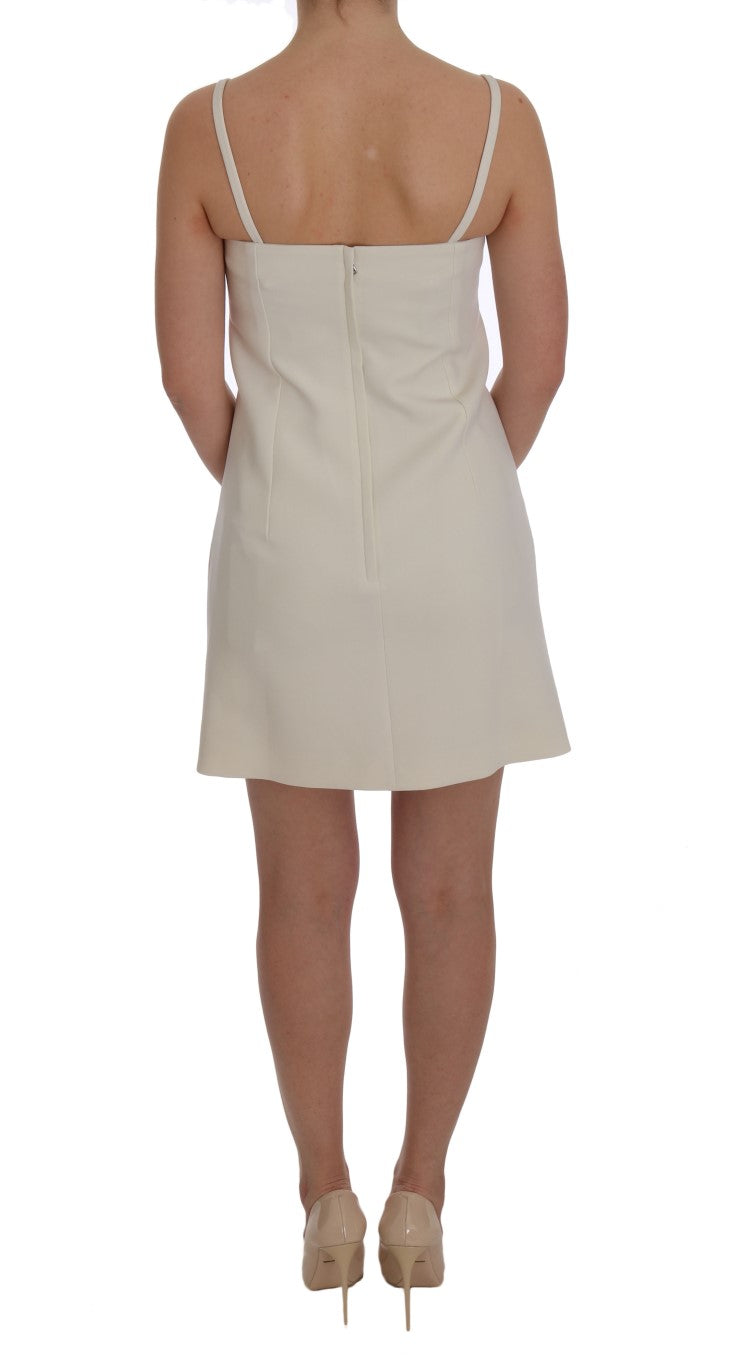 Elegante vestido recto de lana blanca con broche dorado