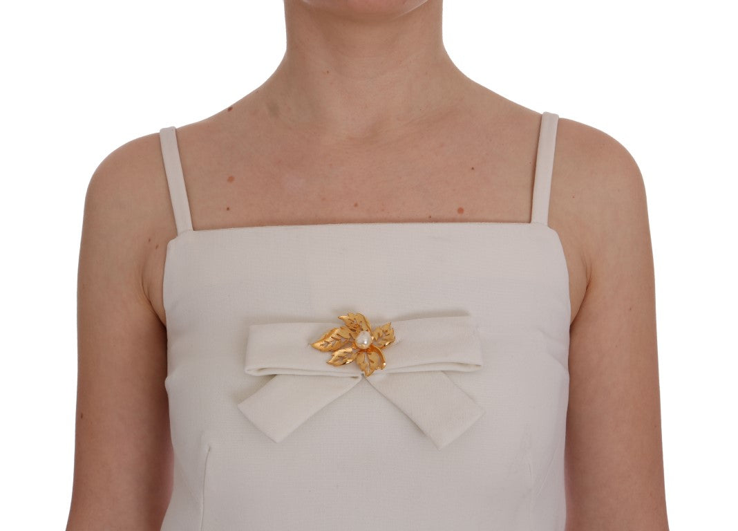 Elegante vestido recto de lana blanca con broche dorado