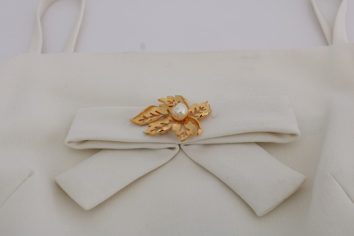 Elegante vestido recto de lana blanca con broche dorado