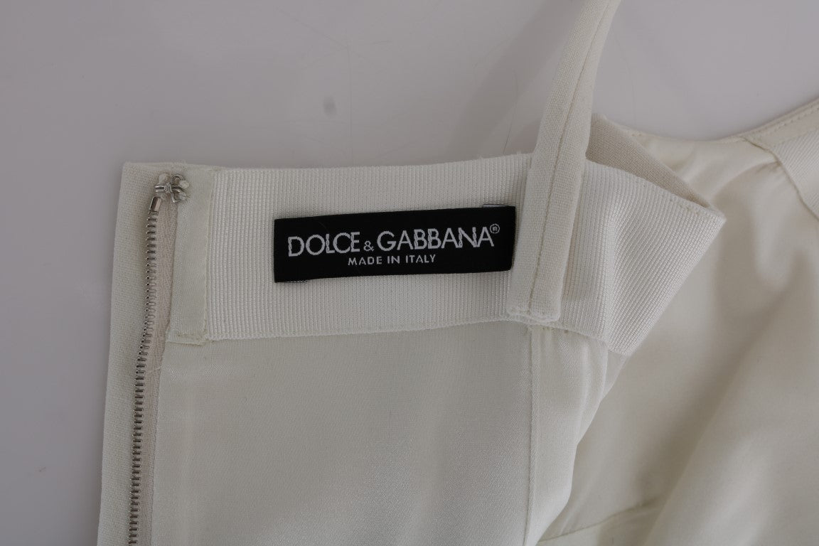 Elegante vestido recto de lana blanca con broche dorado