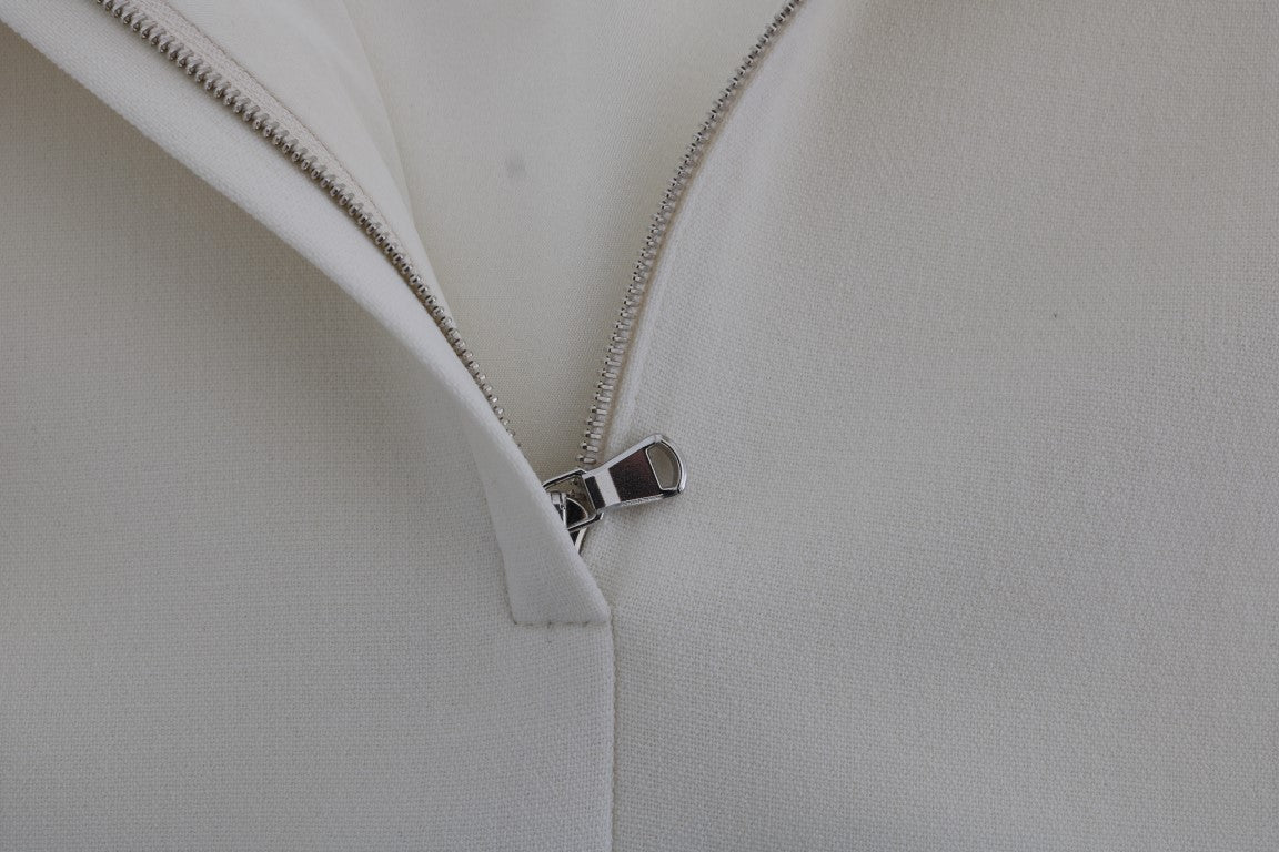 Elegante vestido recto de lana blanca con broche dorado