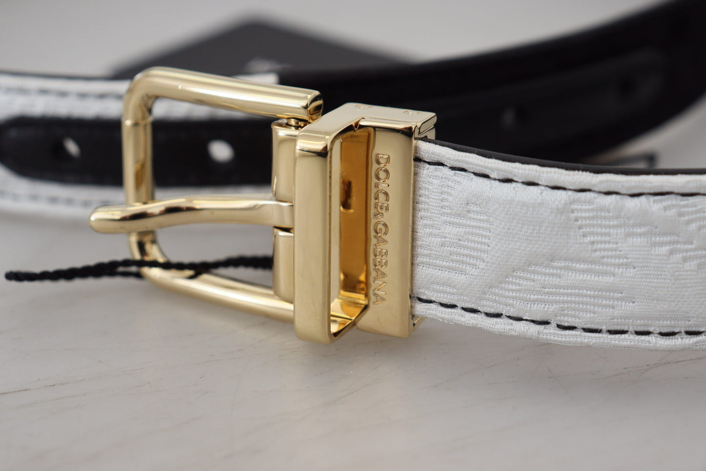 Cinturón con hebilla de metal dorado y patchwork blanco y negro
