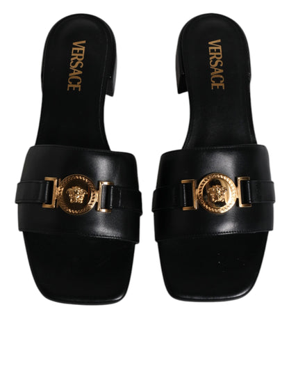 Sandalias planas de cuero negro con placa del logotipo