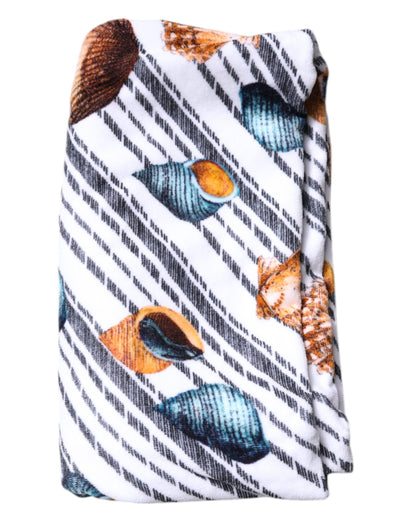 Toalla de playa con rayas multicolores y conchas marinas